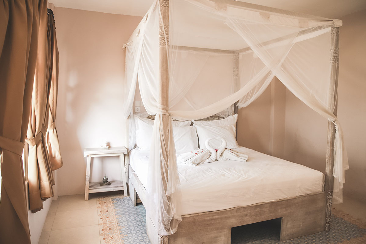 Boutique tropical room with white linens and soft natural textures.