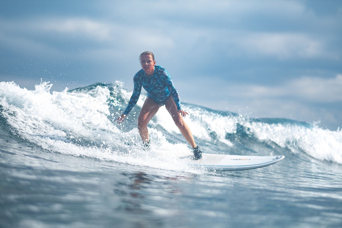 Surfer gliding across clear tropical water.